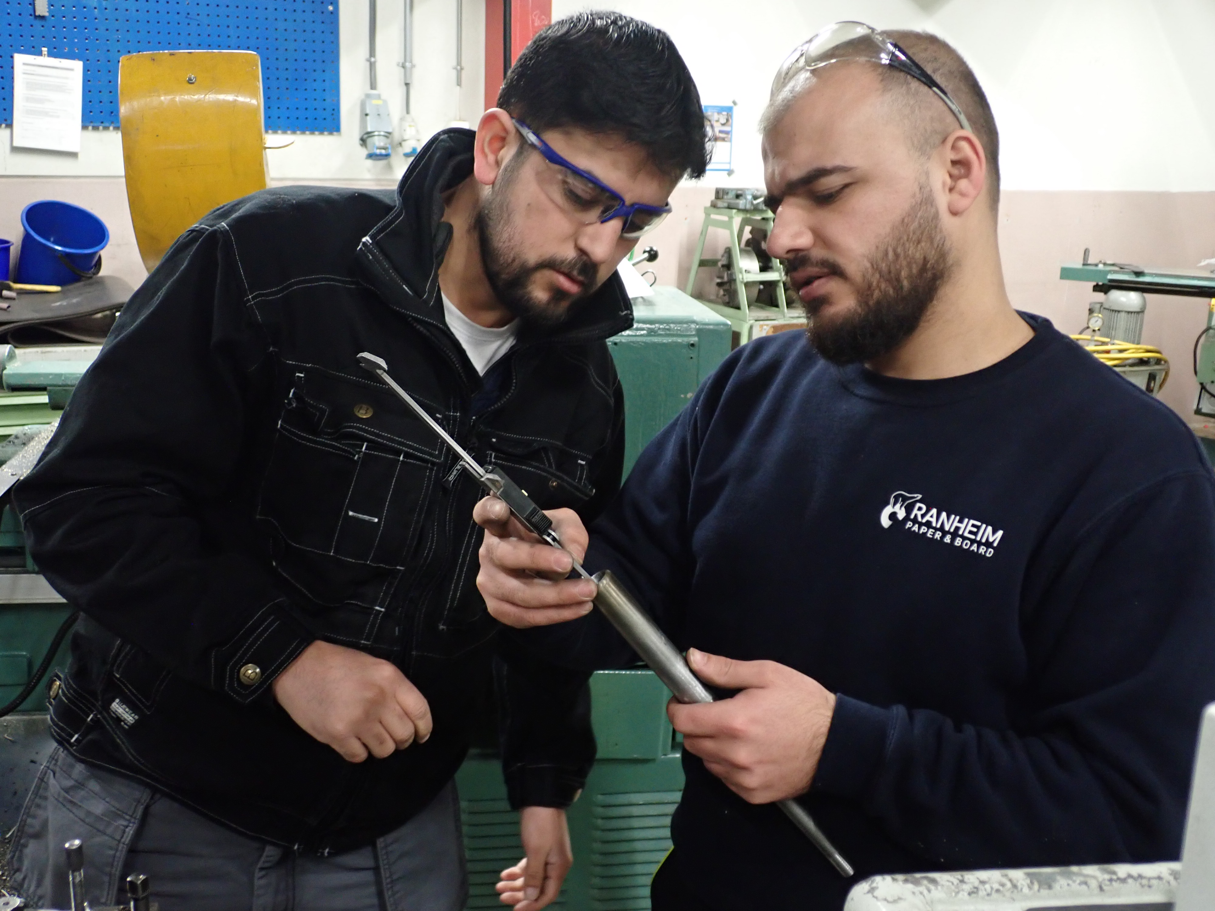 VET students from mechanical industry are learning how to use a tool